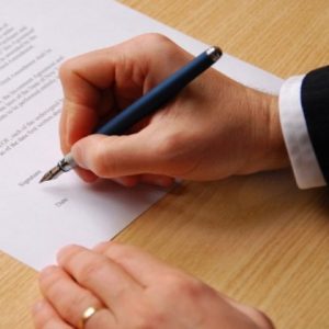 male hand keeping an elegant pen and sihning a contract